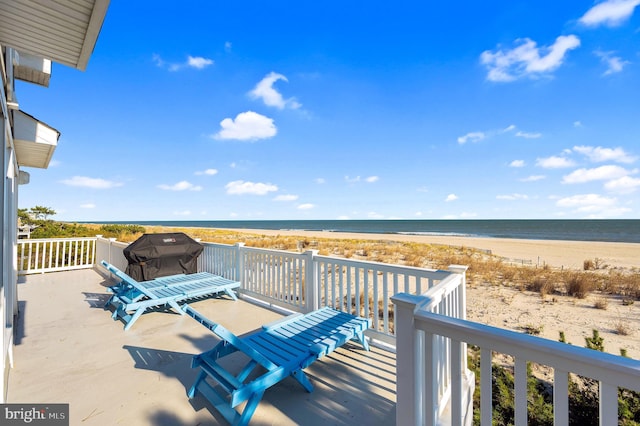 wooden deck with a beach view and a water view