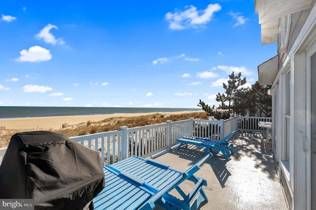 balcony with area for grilling, a water view, and a beach view