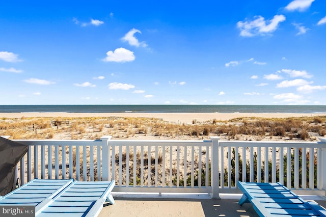 exterior space with a water view and a beach view