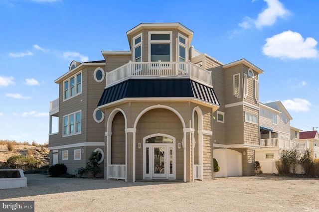 2 N 2nd St, Surf City, NJ 08008 - view of front facade featuring a balcony, a standing seam roof, metal roof, and gravel driveway
