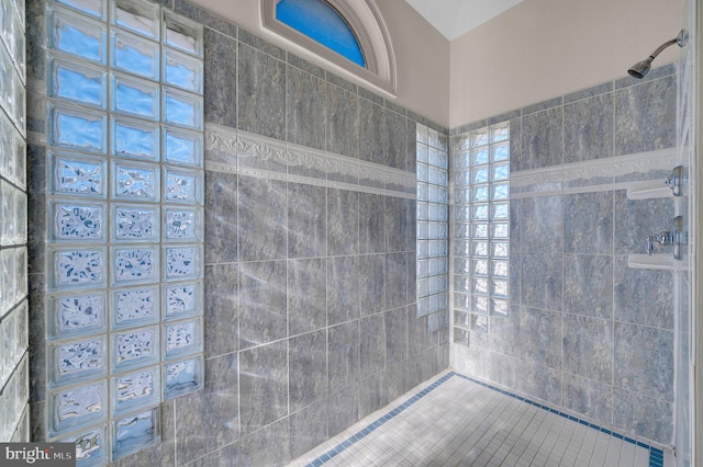 bathroom with a tile shower and a healthy amount of sunlight