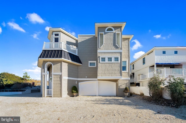2 N 2nd St, Surf City, NJ 08008 - rear view of house featuring a garage, a standing seam roof, a balcony, driveway, and metal roof