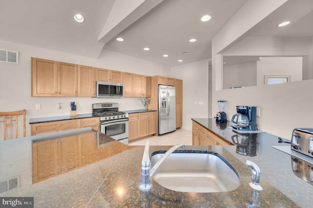 kitchen featuring kitchen peninsula, light brown cabinetry, stainless steel appliances, sink, and light tile patterned flooring