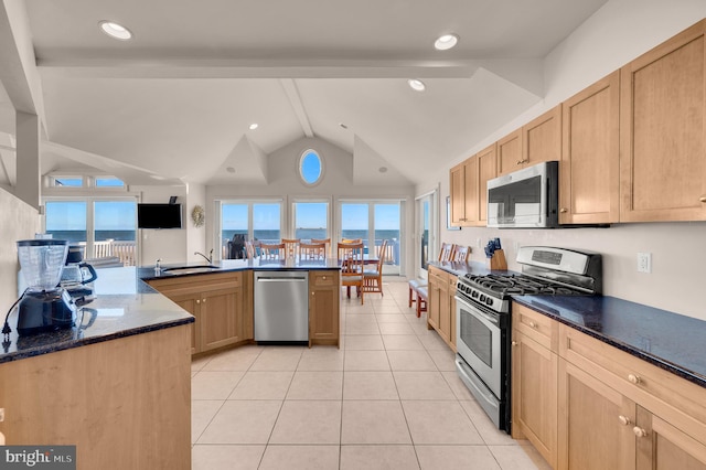 kitchen featuring appliances with stainless steel finishes, sink, dark stone countertops, vaulted ceiling with beams, and light tile patterned flooring