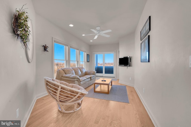 living room featuring ceiling fan and light wood-type flooring