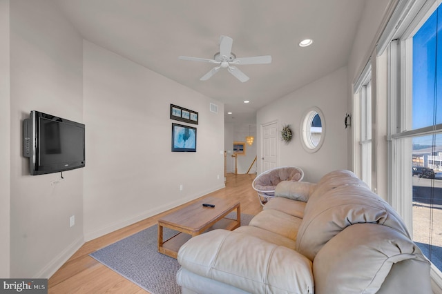 living room featuring light hardwood / wood-style flooring and ceiling fan