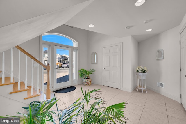 entrance foyer with light tile patterned floors, plenty of natural light, and lofted ceiling