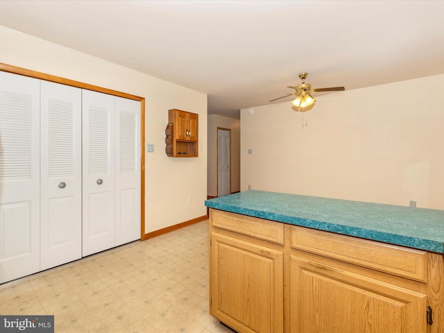 kitchen with ceiling fan and light brown cabinetry