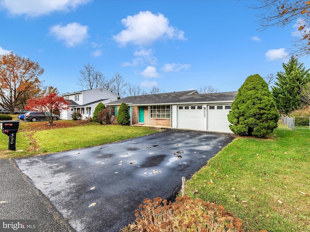 ranch-style home with a garage and a front lawn