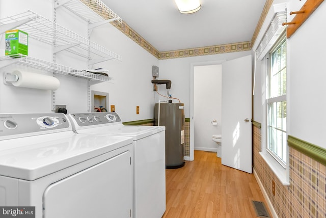 laundry area featuring light hardwood / wood-style flooring, washer and clothes dryer, and water heater