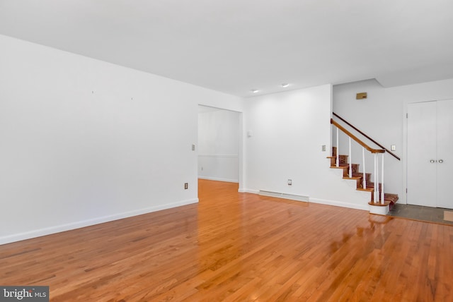 unfurnished living room with a baseboard radiator and light hardwood / wood-style flooring