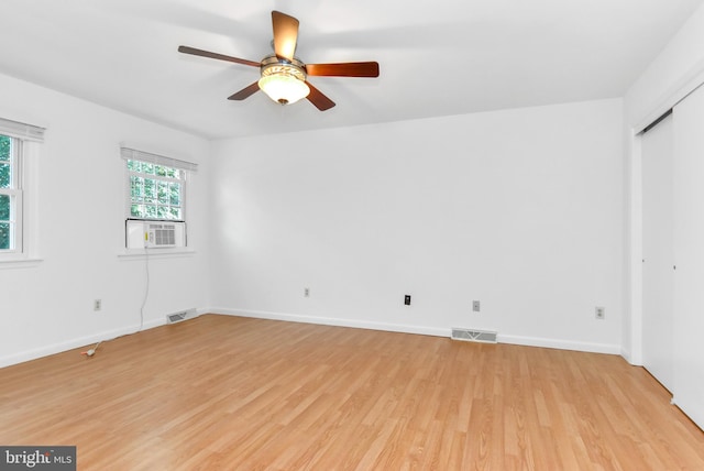 spare room featuring light wood-type flooring, ceiling fan, and cooling unit