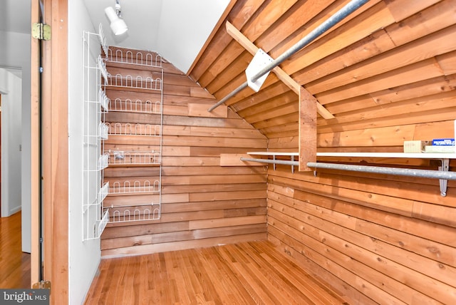 spacious closet featuring hardwood / wood-style floors and vaulted ceiling