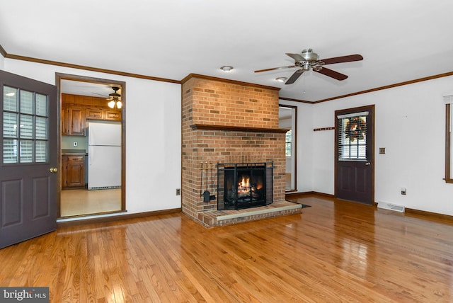 unfurnished living room featuring a fireplace, light wood-type flooring, and crown molding