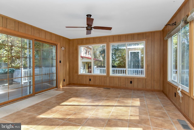 unfurnished sunroom with ceiling fan