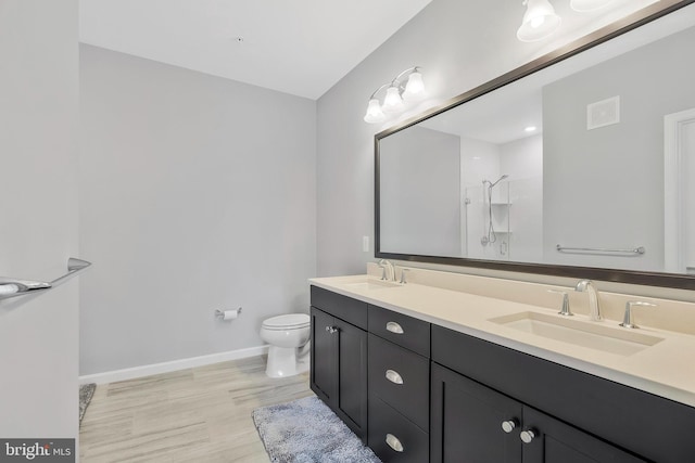 bathroom featuring walk in shower, vanity, toilet, and wood-type flooring