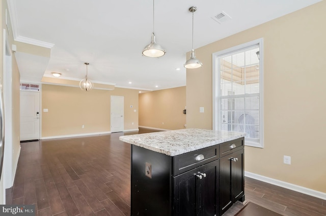 kitchen featuring pendant lighting, dark wood-type flooring, ornamental molding, and a kitchen island