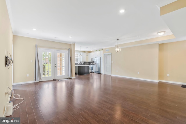 unfurnished living room featuring dark wood-type flooring, french doors, and crown molding