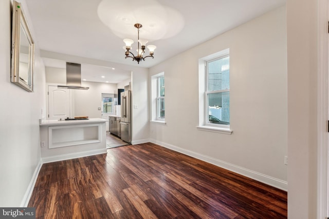 interior space with ventilation hood, stainless steel fridge, hardwood / wood-style floors, black gas stovetop, and a chandelier