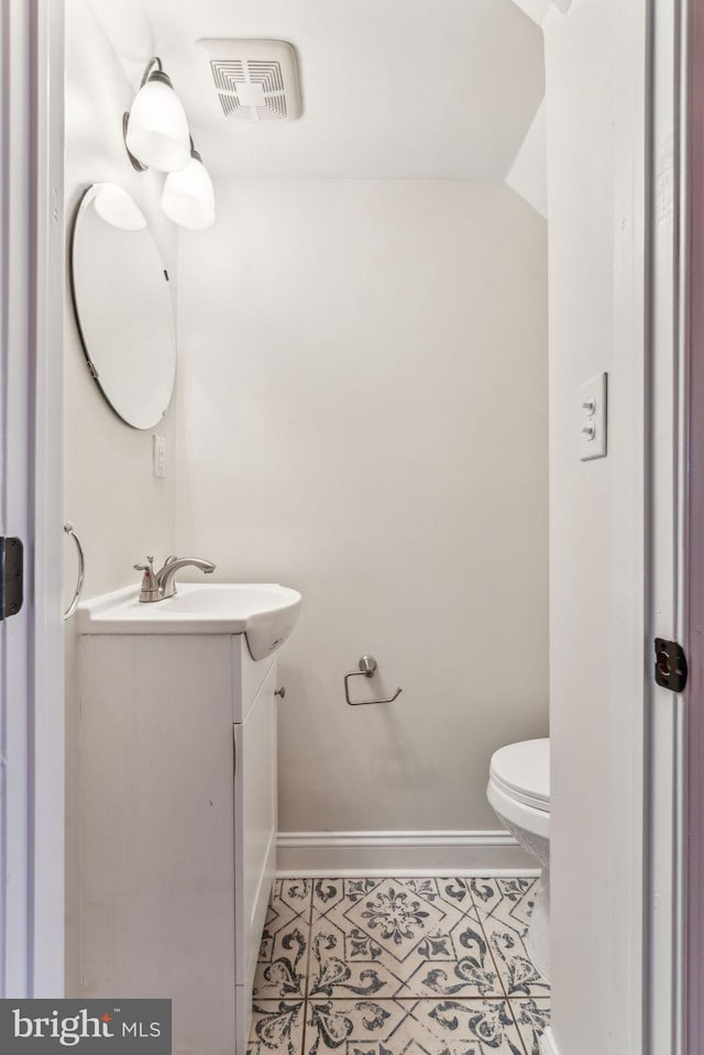 bathroom featuring tile patterned floors, vanity, and toilet