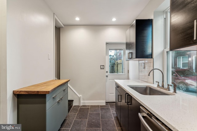 kitchen with stainless steel dishwasher, sink, and butcher block countertops