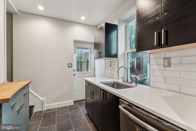 kitchen with dishwasher, butcher block countertops, sink, and tasteful backsplash