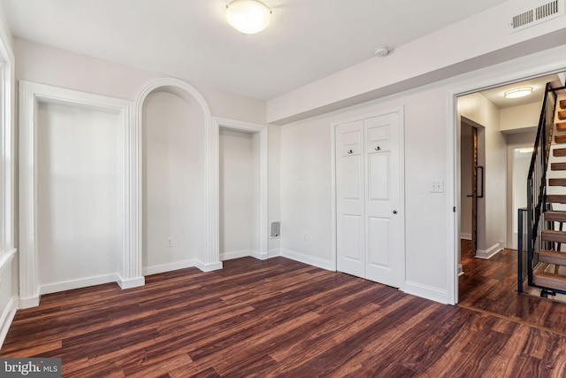 unfurnished bedroom with dark wood-type flooring and a closet