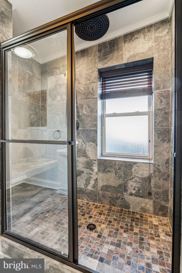 bathroom featuring tile walls, an enclosed shower, and crown molding