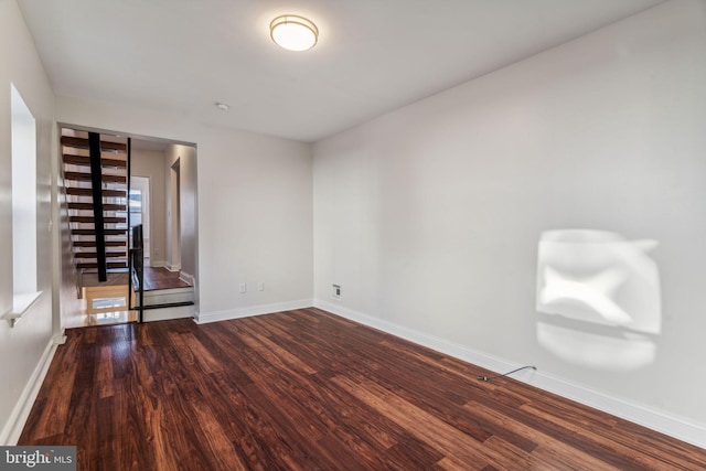 unfurnished room with dark wood-type flooring