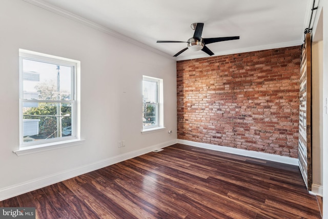 unfurnished room featuring a wealth of natural light, crown molding, brick wall, and dark hardwood / wood-style flooring