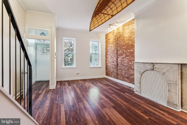 unfurnished living room featuring dark hardwood / wood-style flooring, lofted ceiling, and crown molding