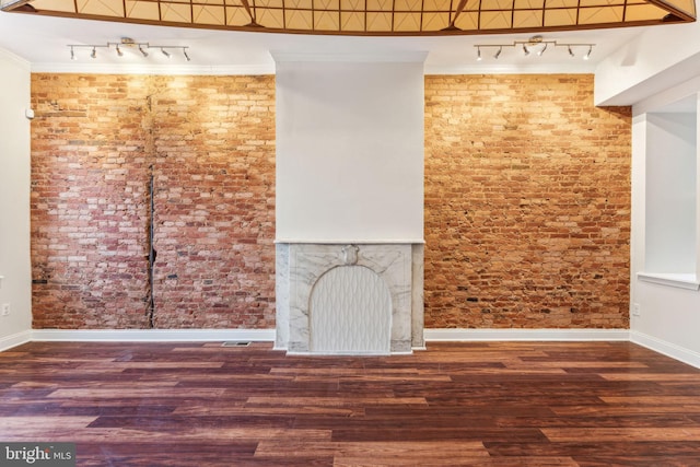 unfurnished living room featuring ornamental molding, track lighting, dark hardwood / wood-style flooring, and a high ceiling