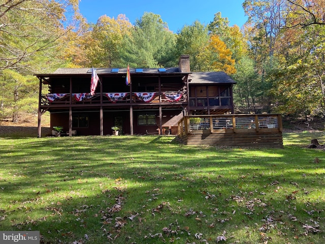 back of property with a yard and a sunroom