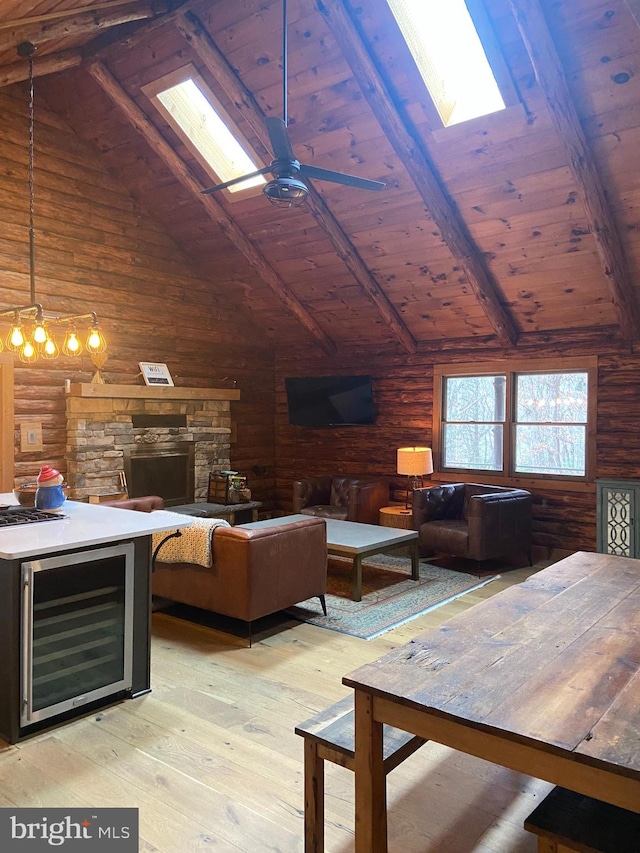 living room featuring light wood-type flooring, wine cooler, wood ceiling, and vaulted ceiling with skylight