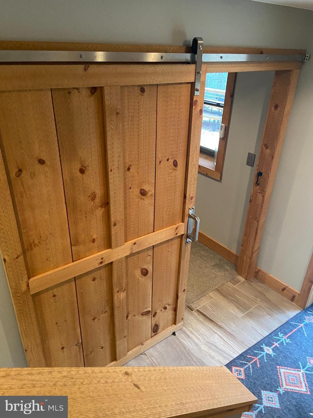 interior details featuring a barn door and hardwood / wood-style flooring