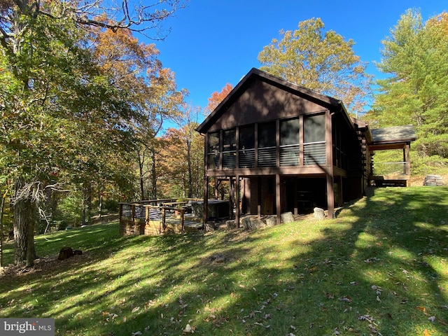 back of property with a lawn and a sunroom