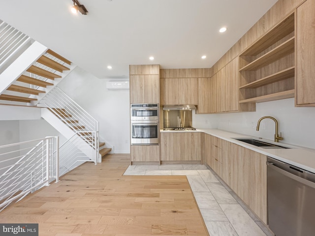 kitchen with stainless steel appliances, sink, extractor fan, light brown cabinets, and light wood-type flooring