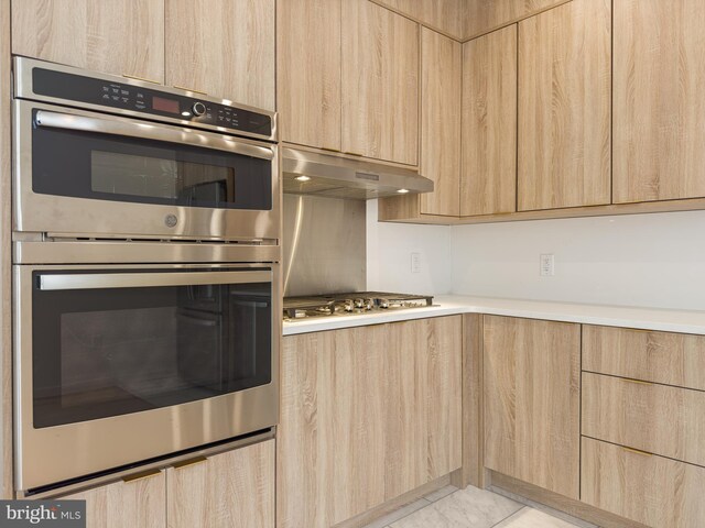 1607 Germantown Ave, Philadelphia, PA 19122 - kitchen featuring light brown cabinetry, modern cabinets, under cabinet range hood, light countertops, and stainless steel appliances
