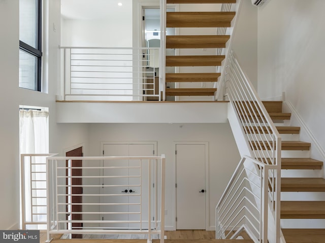 staircase with a high ceiling and hardwood / wood-style floors