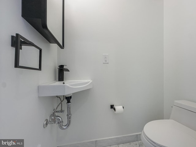 bathroom featuring toilet, sink, and tile patterned floors