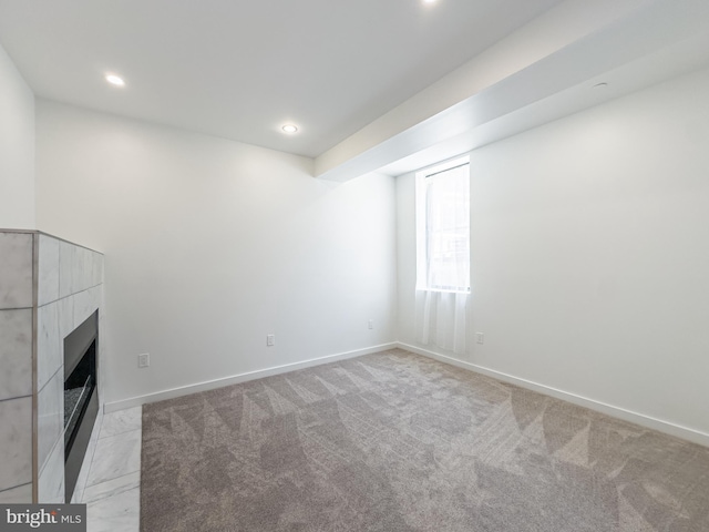 unfurnished living room with light colored carpet and a tiled fireplace