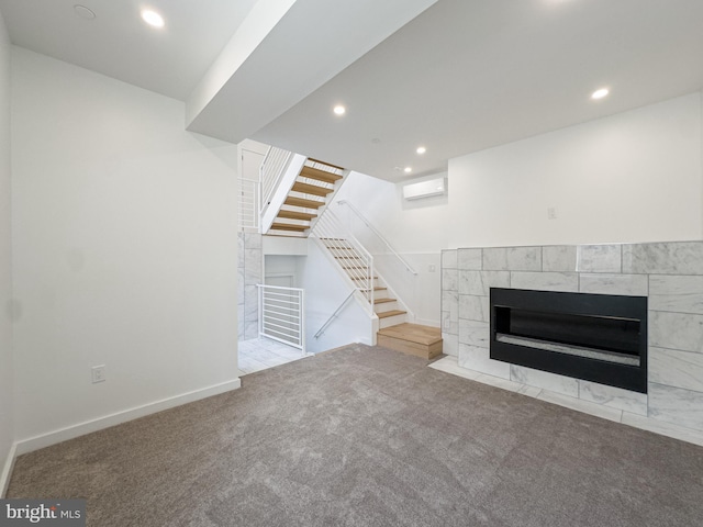 unfurnished living room featuring a wall unit AC, a tile fireplace, and light carpet