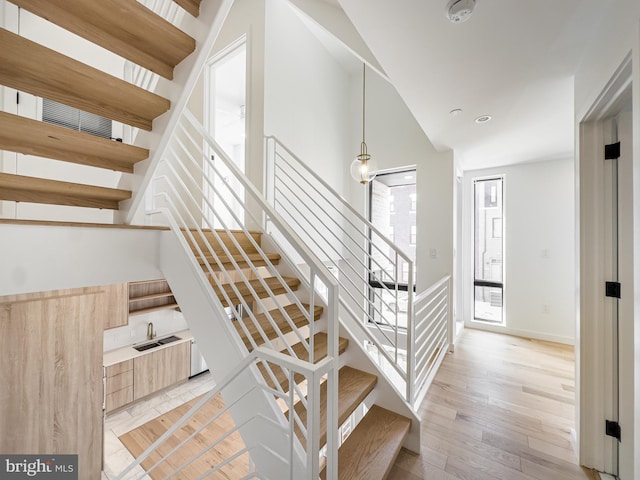 stairway featuring sink and wood-type flooring