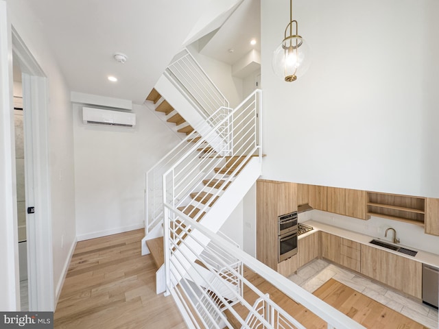 staircase with an AC wall unit, hardwood / wood-style flooring, and sink