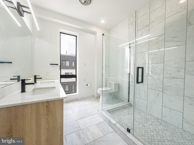 bathroom featuring a shower with shower door, vanity, and toilet