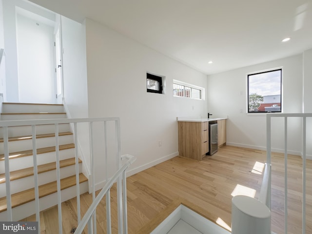 unfurnished office featuring beverage cooler and light hardwood / wood-style floors