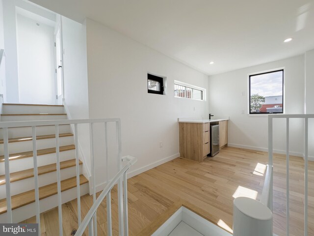 1607 Germantown Ave, Philadelphia, PA 19122 - indoor wet bar featuring light wood finished floors, recessed lighting, baseboards, stairway, and wine cooler
