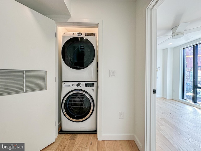 laundry area featuring ceiling fan, light hardwood / wood-style floors, and stacked washer and dryer