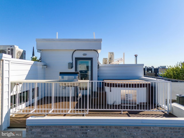 rear view of property featuring central air condition unit and a balcony