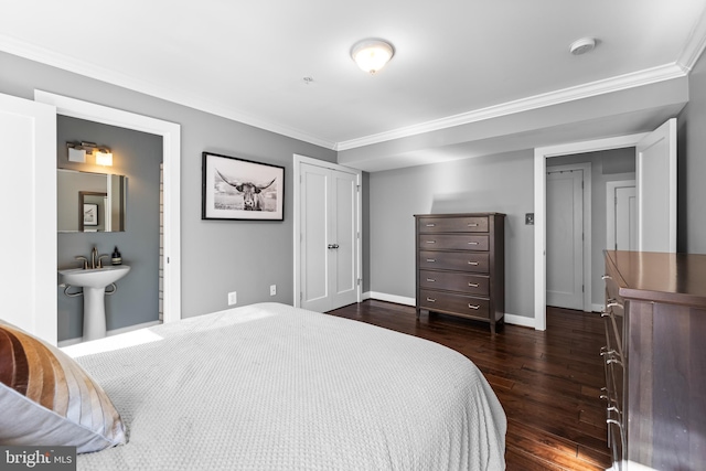 bedroom with crown molding, dark wood-type flooring, and ensuite bathroom